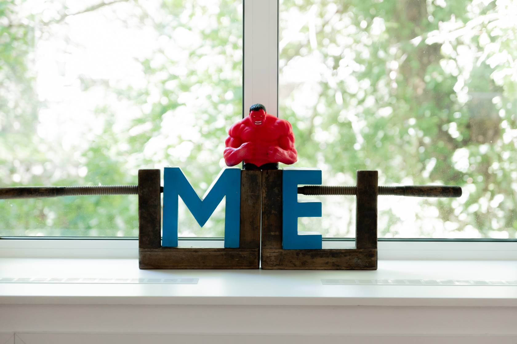Rote Hulk-Actionfigur stehend auf den Buchstaben M und E